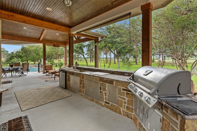 view of patio with area for grilling, sink, and exterior kitchen