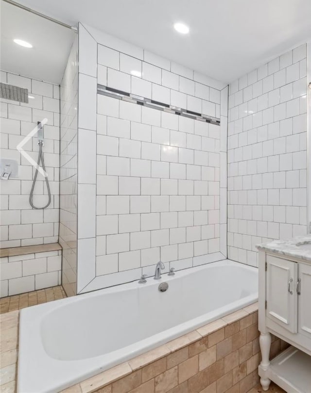 bathroom with a tile shower and vanity