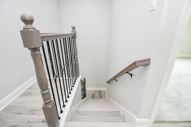 staircase with hardwood / wood-style flooring