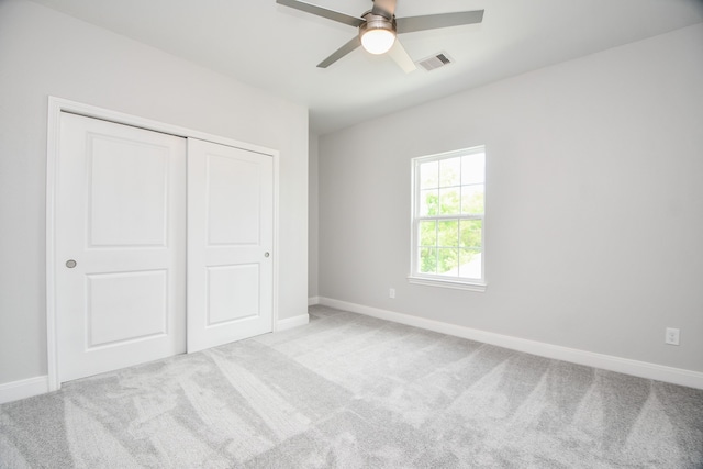 unfurnished bedroom with a closet, ceiling fan, and light colored carpet