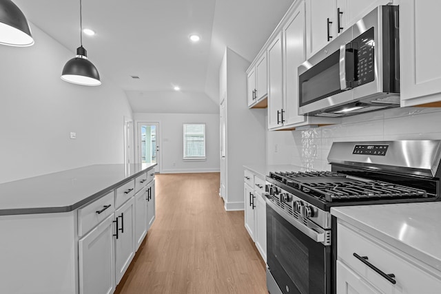 kitchen with white cabinetry, pendant lighting, lofted ceiling, and appliances with stainless steel finishes