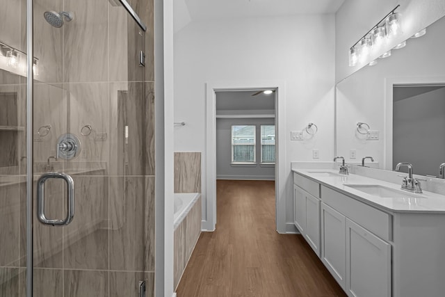 bathroom with wood-type flooring, shower with separate bathtub, and vanity