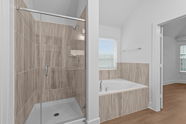 bathroom with lofted ceiling, shower with separate bathtub, and hardwood / wood-style floors