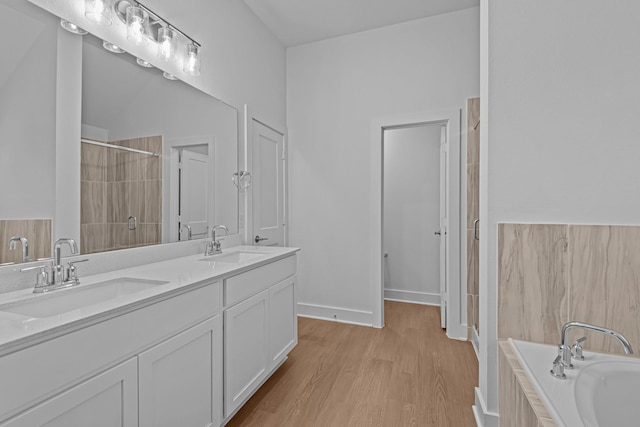 bathroom with vanity, hardwood / wood-style floors, and a bathing tub