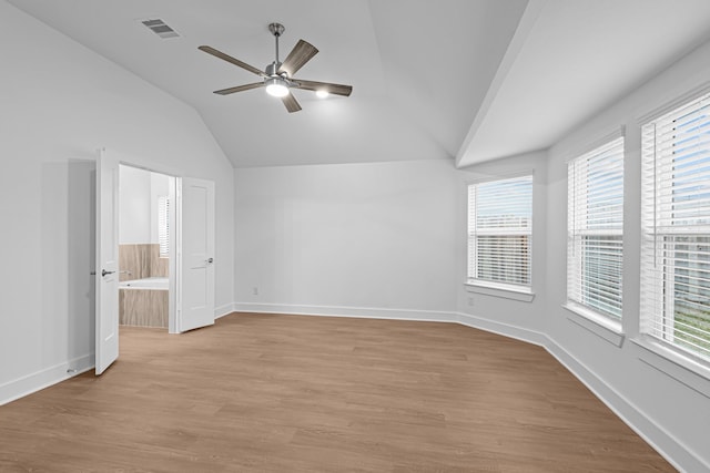 interior space with multiple windows, connected bathroom, ceiling fan, and light hardwood / wood-style floors