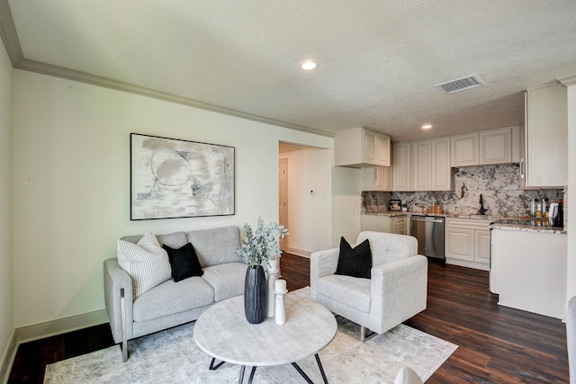 living room with crown molding, dark wood-type flooring, a textured ceiling, and sink