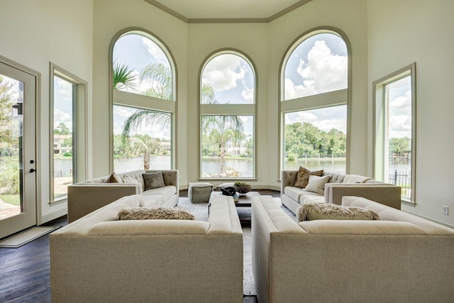 living room featuring a water view, dark hardwood / wood-style flooring, and ornamental molding