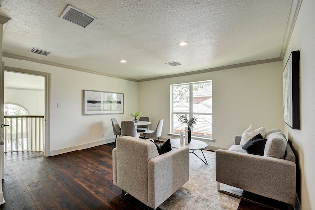 living room featuring a textured ceiling, ornamental molding, and wood-type flooring