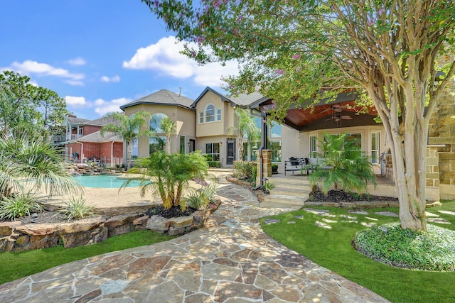 back of property with a lawn, ceiling fan, and a patio