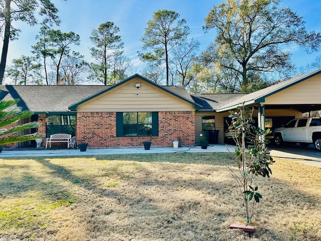 ranch-style home with a front yard and a carport