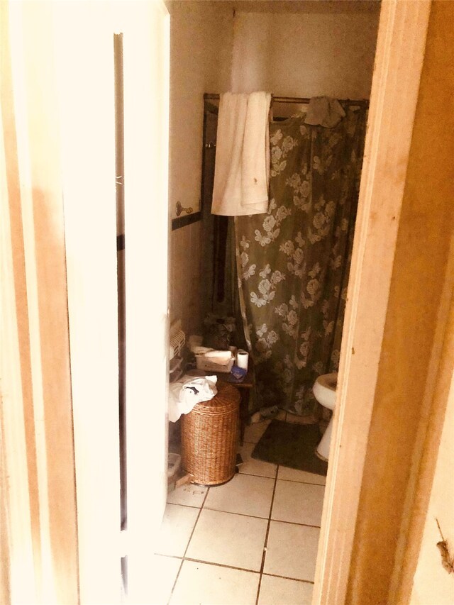 bathroom featuring toilet and tile patterned flooring