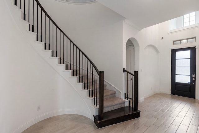 foyer featuring a towering ceiling and light hardwood / wood-style flooring