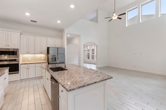 kitchen with ceiling fan, sink, appliances with stainless steel finishes, and white cabinetry