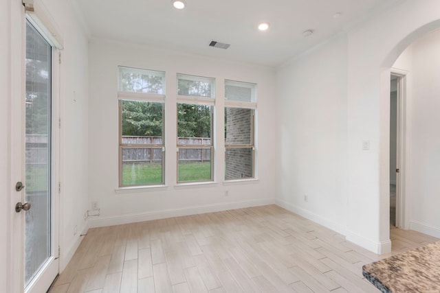 unfurnished room featuring crown molding and light wood-type flooring