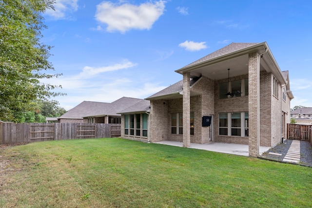 rear view of house featuring a lawn and a patio