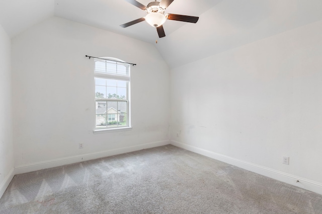 carpeted empty room featuring vaulted ceiling and ceiling fan