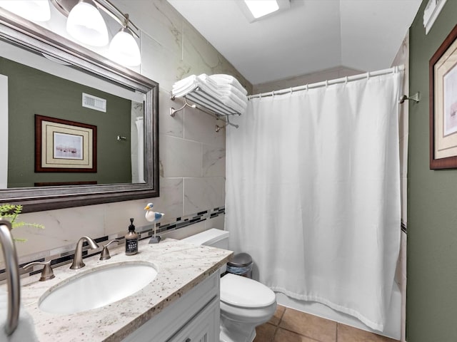 bathroom featuring visible vents, toilet, tile walls, vanity, and tile patterned floors