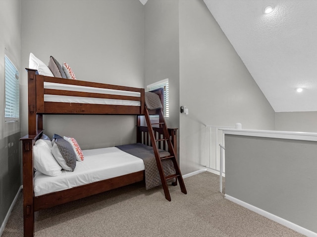 bedroom with high vaulted ceiling and carpet