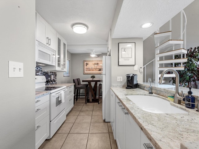 kitchen with white appliances, white cabinetry, a textured ceiling, open shelves, and a sink