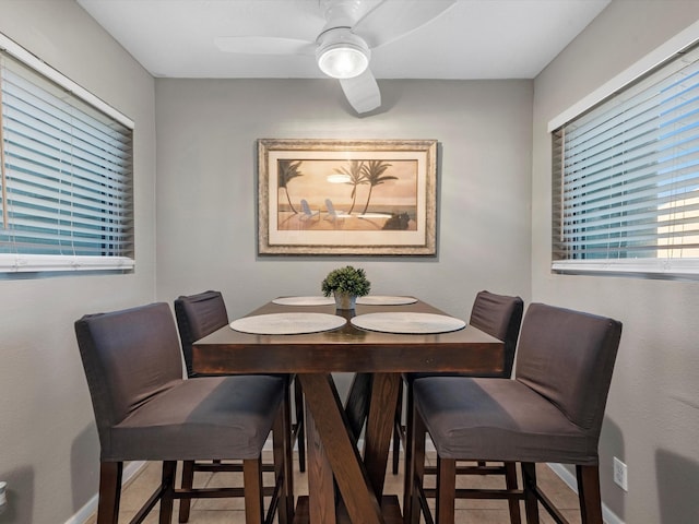 tiled dining space with ceiling fan