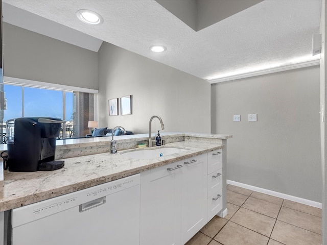 kitchen featuring light stone countertops, white cabinetry, light tile patterned flooring, dishwasher, and a sink