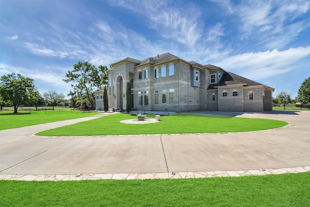 view of front of property featuring a fire pit, a front yard, and a garage