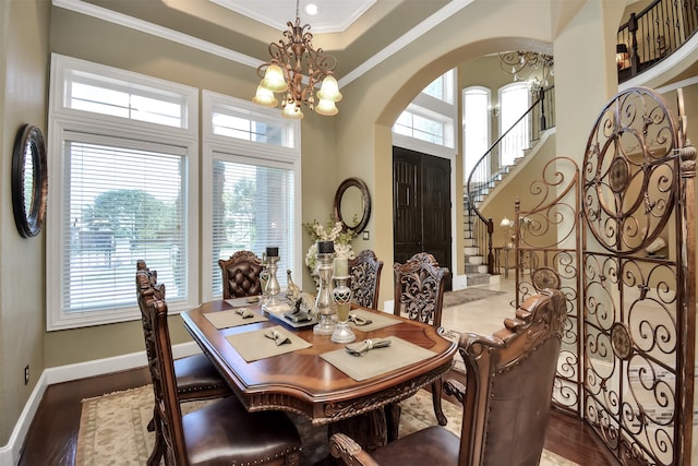 dining room featuring a tray ceiling, dark hardwood / wood-style floors, crown molding, and a notable chandelier