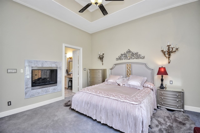 carpeted bedroom featuring ceiling fan, a multi sided fireplace, and crown molding