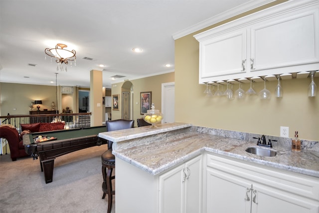 kitchen featuring pool table, crown molding, light colored carpet, white cabinetry, and sink