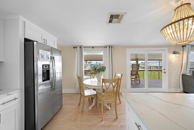 417 Olive St, Surfside Beach, TX 77541 - dining room with baseboards, a notable chandelier, light wood-style flooring, and visible vents