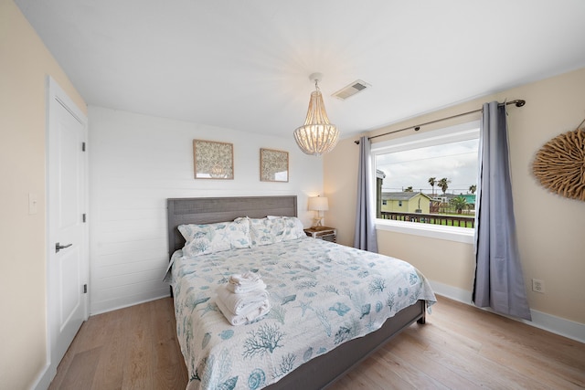 417 Olive St, Surfside Beach, TX 77541 - bedroom with a chandelier, baseboards, visible vents, and wood finished floors