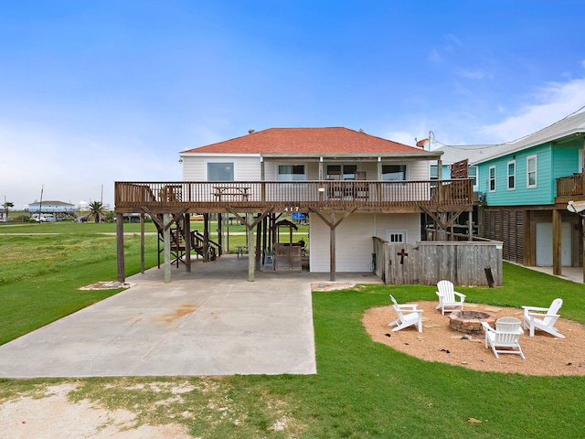 rear view of house featuring a yard, a patio, a fire pit, and a deck