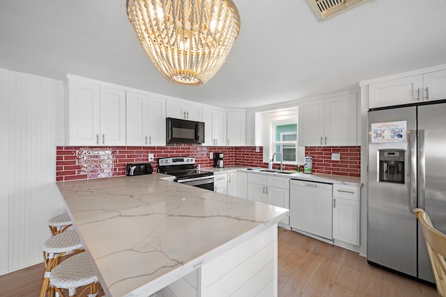 417 Olive St, Surfside Beach, TX 77541 - kitchen featuring a sink, tasteful backsplash, visible vents, a chandelier, and appliances with stainless steel finishes