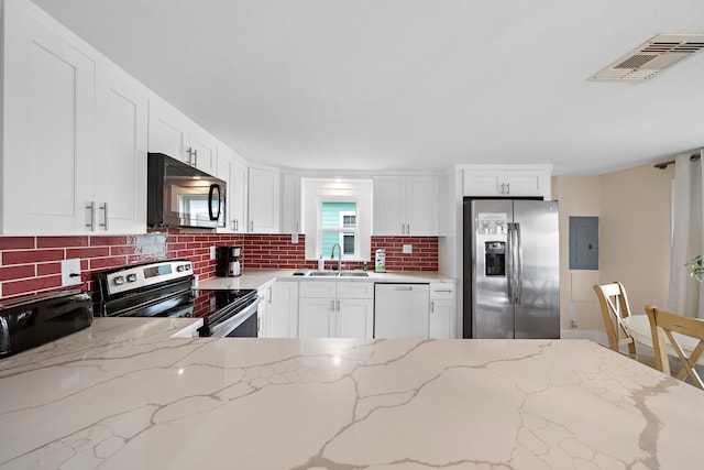 kitchen with appliances with stainless steel finishes, tasteful backsplash, white cabinetry, electric panel, and light stone counters