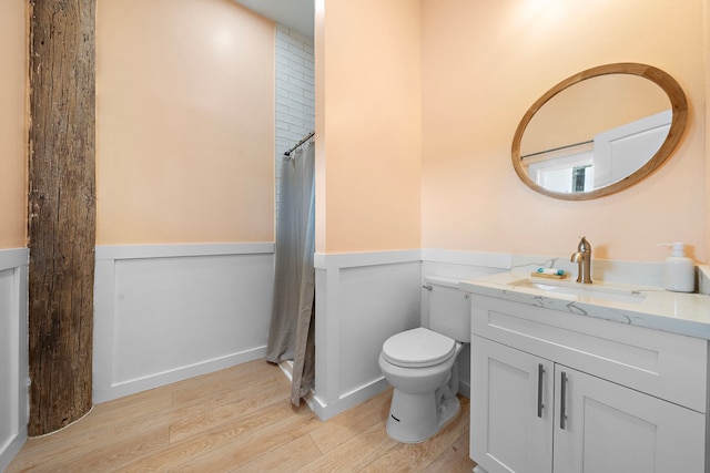 417 Olive St, Surfside Beach, TX 77541 - full bath featuring toilet, wood finished floors, vanity, wainscoting, and a shower with shower curtain