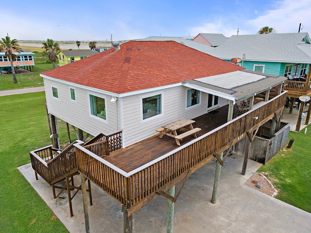 417 Olive St, Surfside Beach, TX 77541 - back of house featuring a yard, a wooden deck, and a shingled roof
