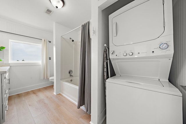 417 Olive St, Surfside Beach, TX 77541 - clothes washing area featuring stacked washer and clothes dryer, light wood-style flooring, laundry area, visible vents, and baseboards