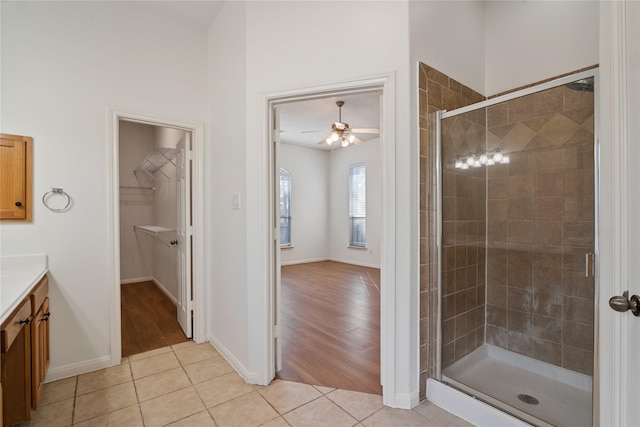 bathroom featuring ceiling fan, tile patterned flooring, vanity, and walk in shower