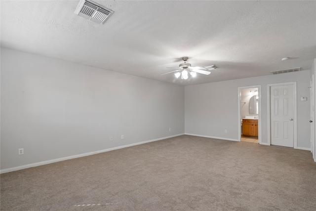 carpeted spare room featuring ceiling fan and a textured ceiling