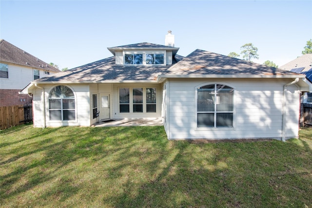 rear view of property with a yard and a patio