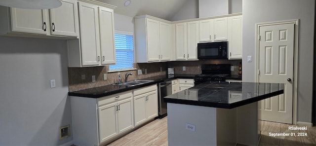 kitchen featuring white cabinetry, sink, decorative backsplash, a kitchen island, and black appliances