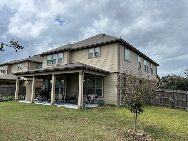 back of house featuring a yard, fence, and a patio