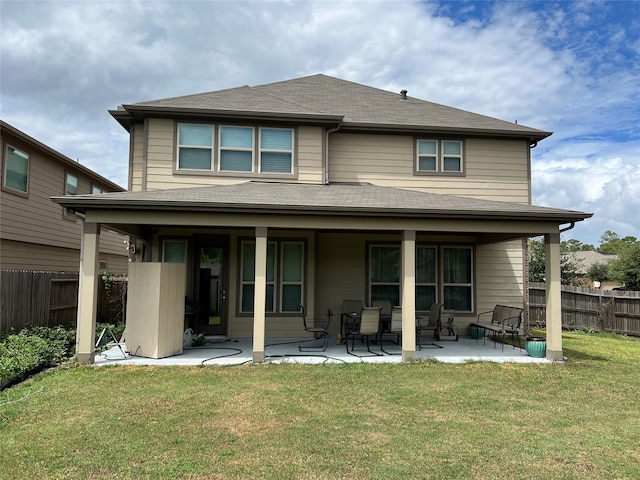 back of property with a lawn and a patio