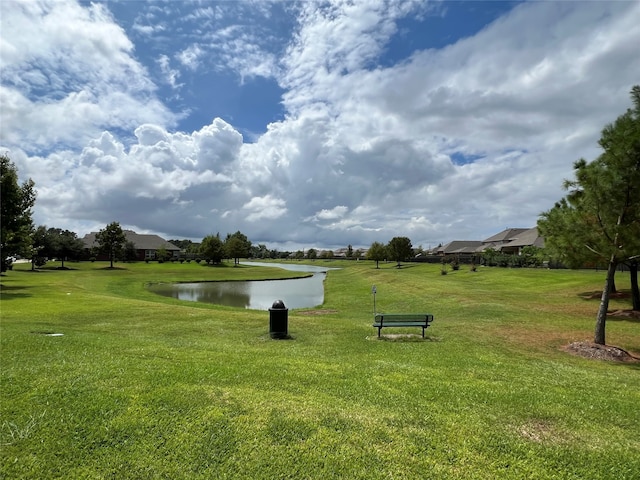 view of community featuring a water view and a yard