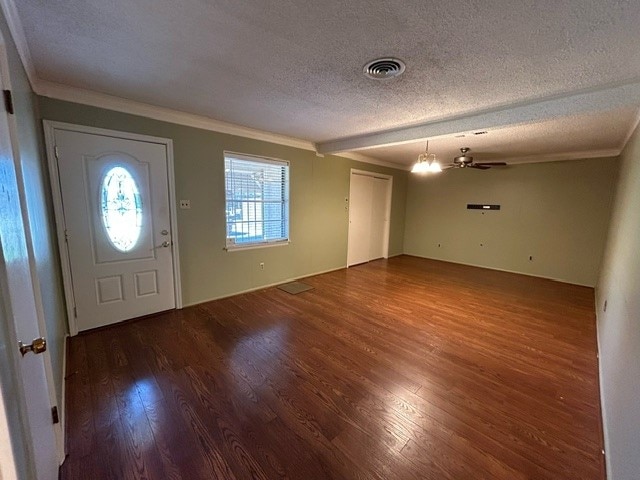 foyer entrance featuring a textured ceiling, crown molding, an inviting chandelier, and dark hardwood / wood-style flooring