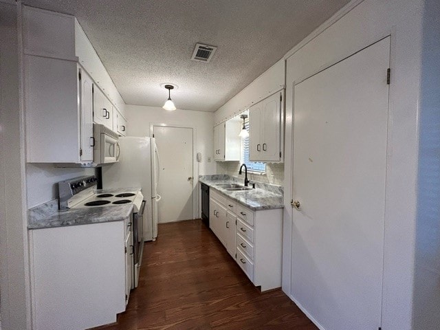 kitchen with white cabinets, white appliances, sink, dark wood-type flooring, and a textured ceiling