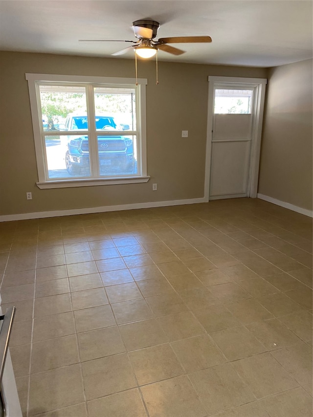 tiled spare room featuring ceiling fan and a wealth of natural light