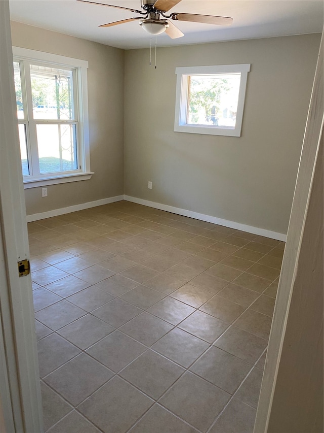 tiled spare room featuring ceiling fan