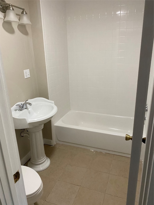 bathroom with tile patterned flooring, toilet, and bathing tub / shower combination