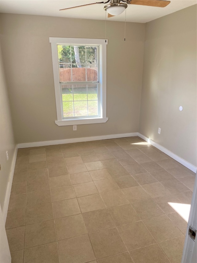 spare room with ceiling fan and light tile patterned flooring